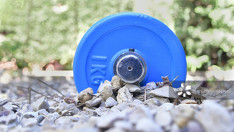 半埋在砾石中的哑铃图片素材