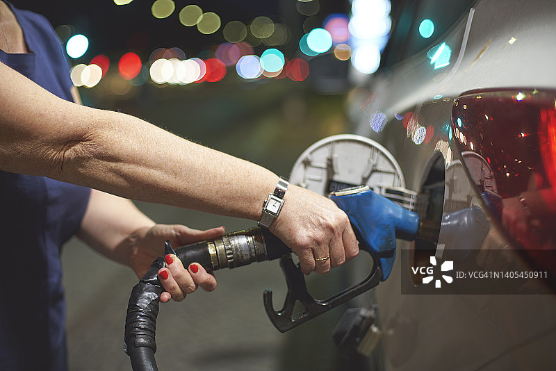 在加油站给汽车加油的女人图片素材