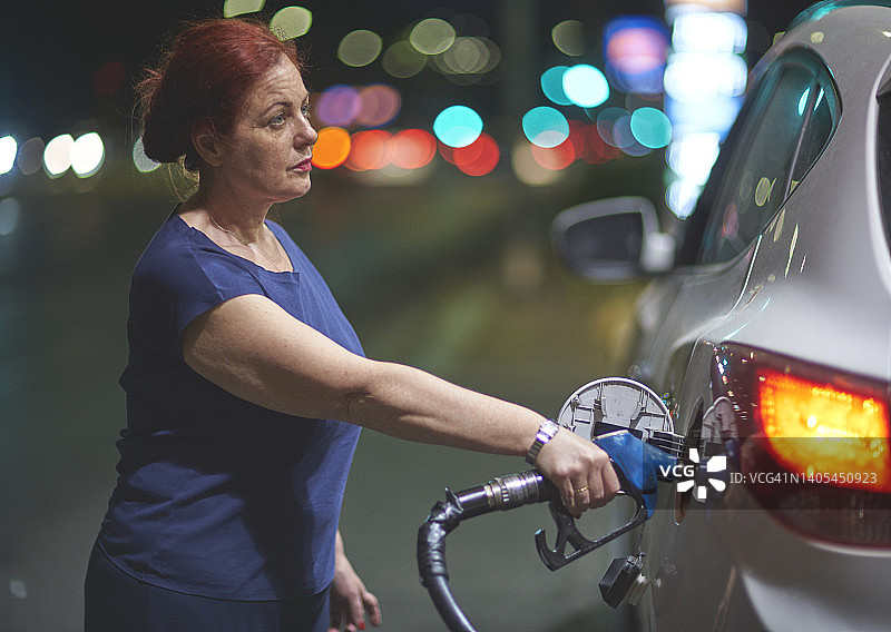 在加油站给汽车加油的女人图片素材