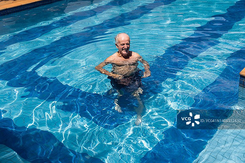 在游泳池里微笑的老年人图片素材