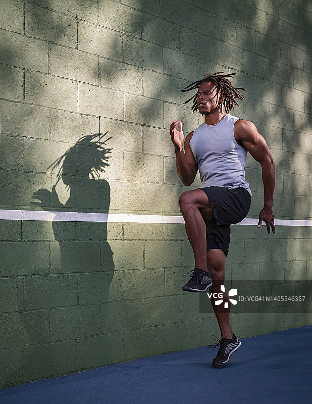 健壮男人在墙边跳跃图片素材