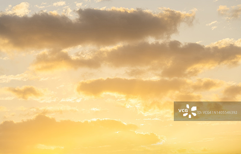 日出时分，金色天空下的积云图片素材