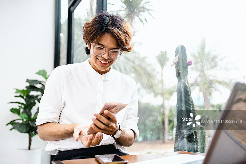 在家办公的自由平面设计师数着钞票图片素材