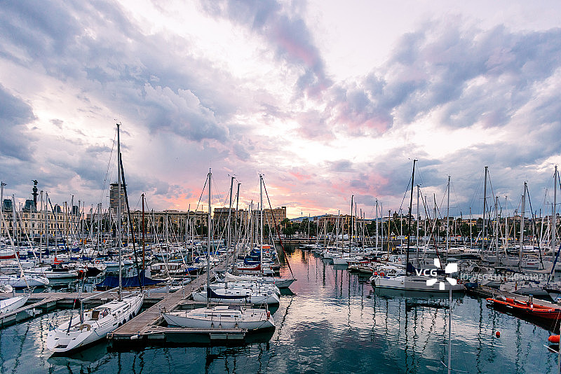 日落时分停泊在西班牙巴塞罗那韦尔港的游艇图片素材
