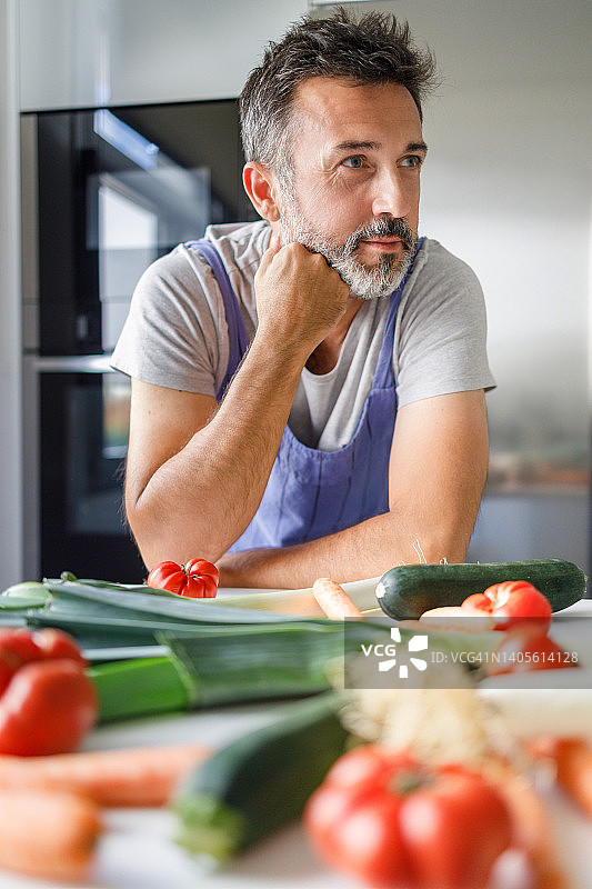 五十岁留胡须男人厨房新鲜蔬菜图片素材