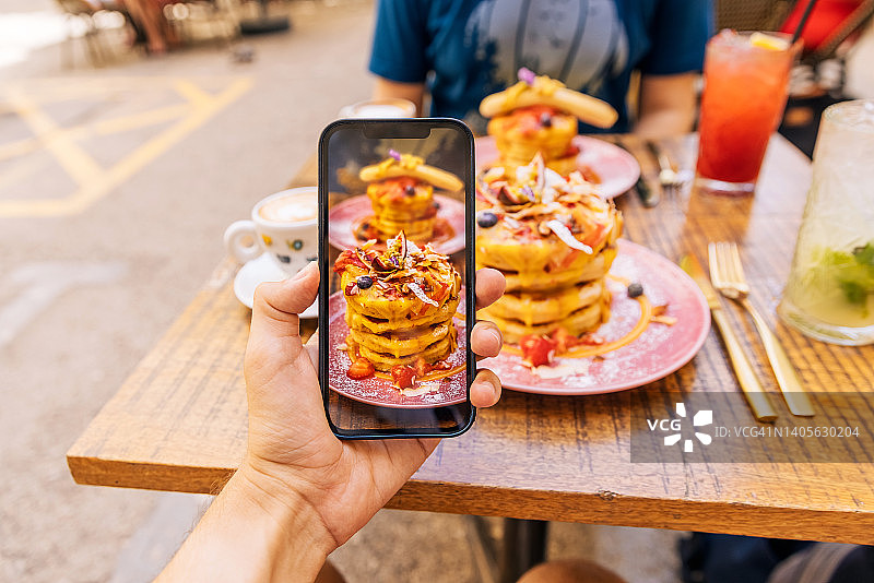 用智能手机在咖啡馆拍摄早午餐图片素材
