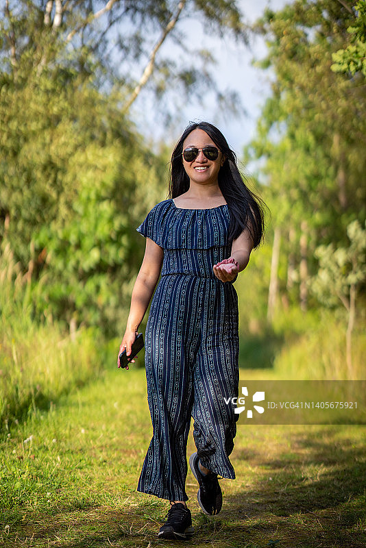 在法尔松草地上轻快行走的女子图片素材