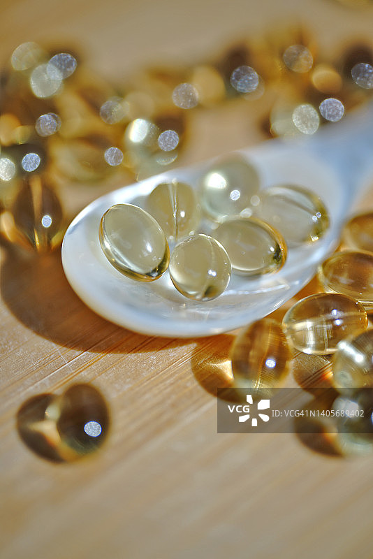 木桌上的维生素D胶囊特写图片素材