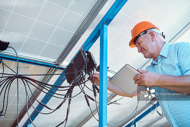 工人参考平板教程安装太阳能板电缆图片素材