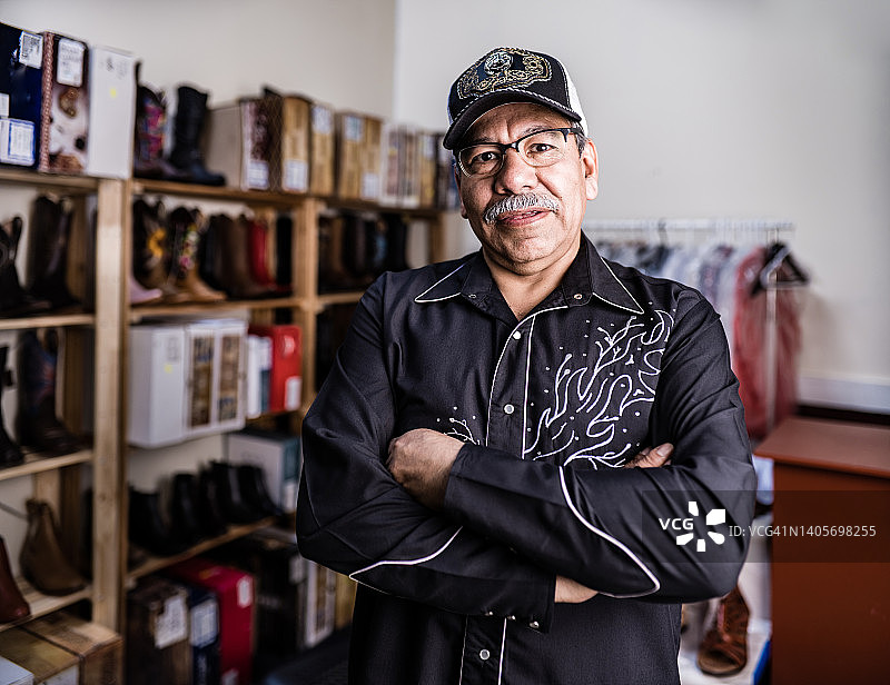 打扮成墨西哥牛仔的年长的拉丁裔店主画像图片素材