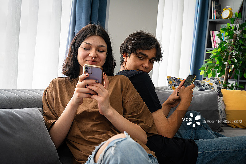 嫉妒的男朋友偷看女朋友的手机图片素材