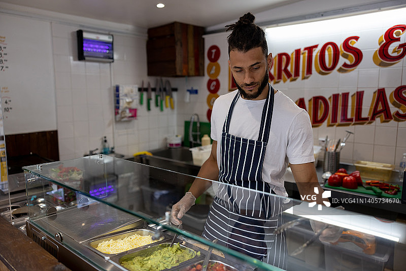 男人在墨西哥街头食品店工作图片素材