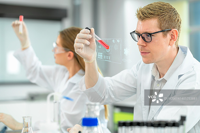科学家在医学实验室检查试管中的科学样本结果并进行医学研究，微观生物实验室研究和科学图片素材