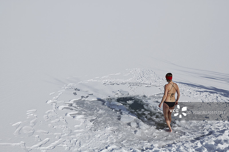 独自在冰冻湖泊中进行冰浴的女子图片素材