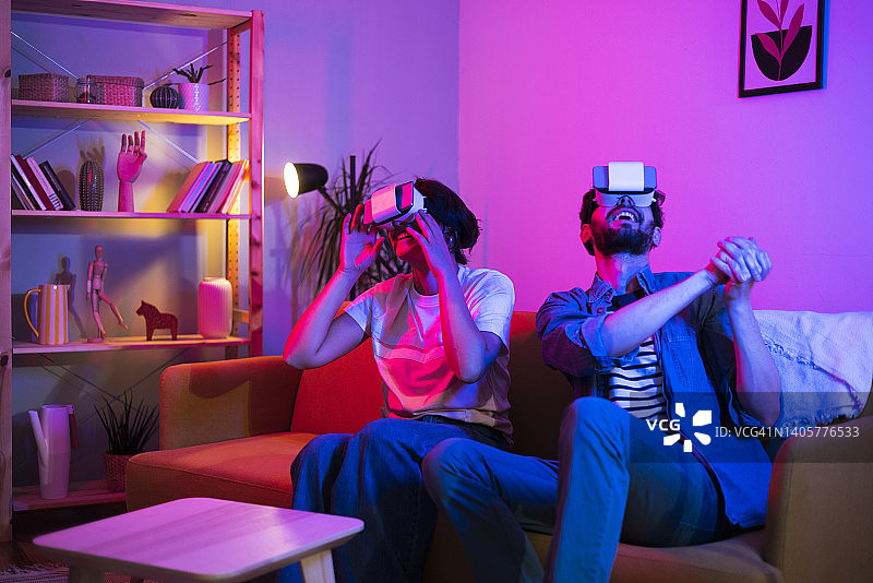 年轻情侣使用VR眼镜玩游戏图片素材