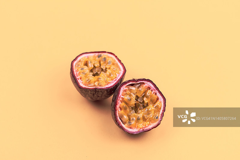 橙色背景上的对半切百香果图片素材