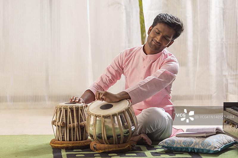 年轻男子在家演奏塔布拉鼓人像图片素材