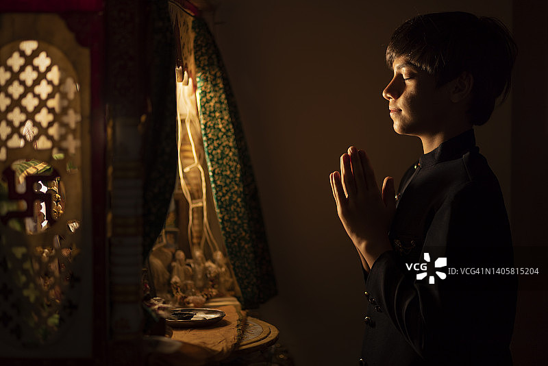 双手合十祈祷的青少年男孩肖像图片素材