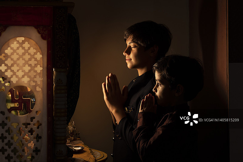 两个兄弟合手祈祷的合影图片素材