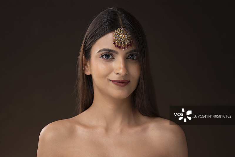 佩戴精美额饰的年轻女子肖像照图片素材