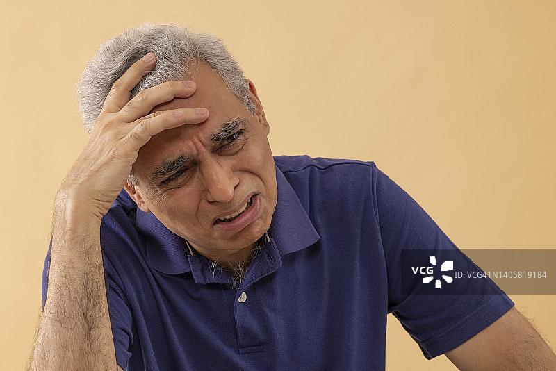 特写的一个悲伤的年长男子哭泣的手在头上图片素材