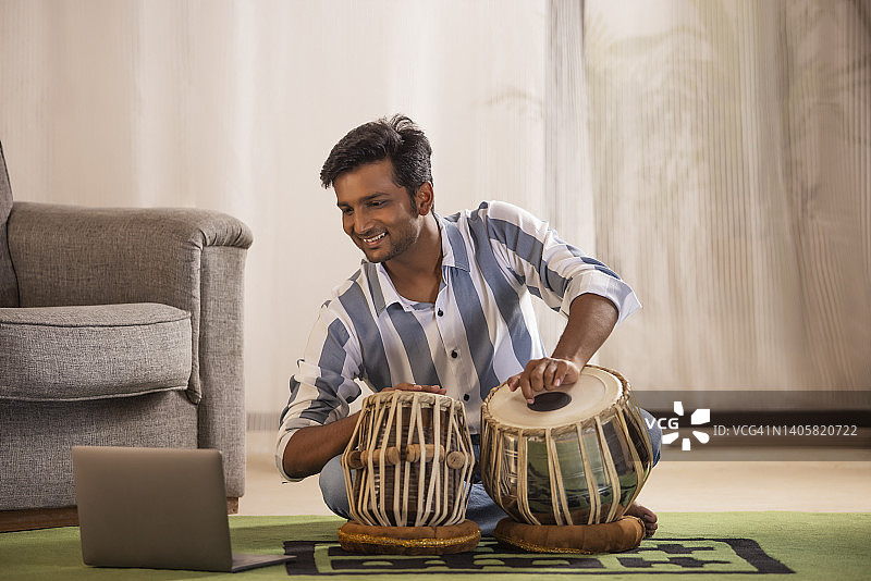 年轻男子上在线塔布拉鼓课程的肖像图片素材