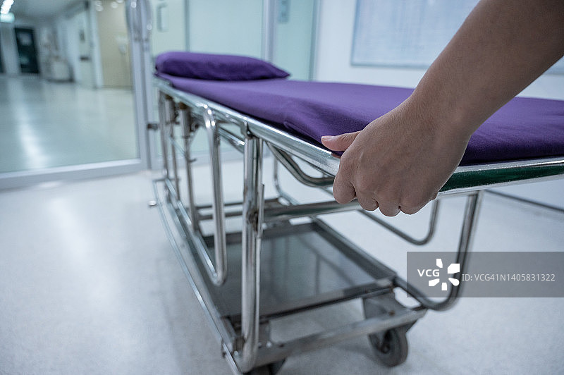医护人员在医院走廊拉着没有病人的急救担架的局部照片图片素材
