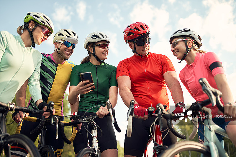一群骑公路自行车的友人看手机图片素材
