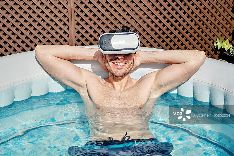 戴VR眼镜的男人在热水浴缸里图片素材