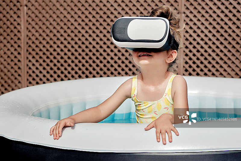 女孩在泳池里玩VR眼镜图片素材