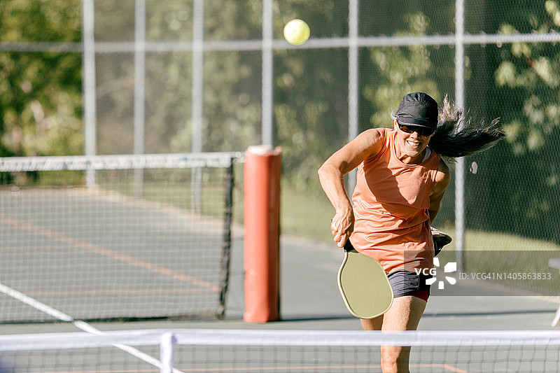 中年妇女在夏日早晨打匹克球图片素材