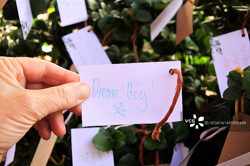 女人手持写着“dream big”的卡片图片素材