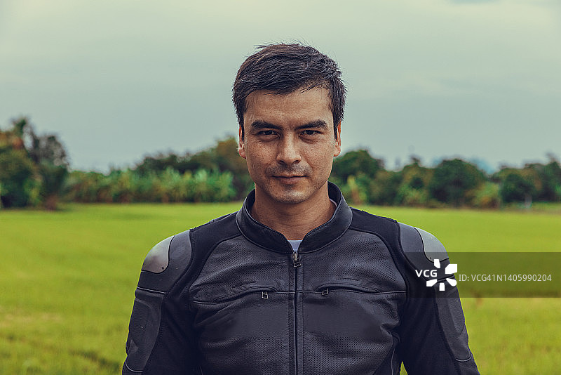 骑摩托车的人在稻田背景下的肖像图片素材