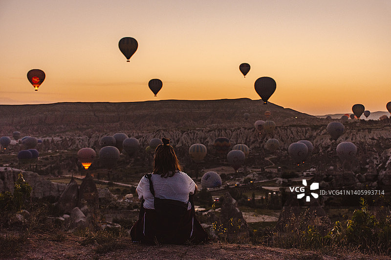 在卡帕多西亚观看日出的背包女子的背影图片素材