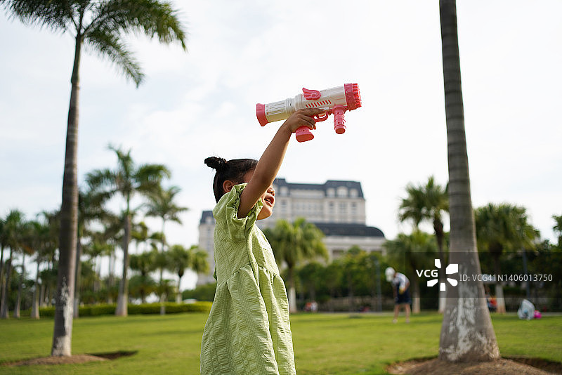 小女孩在公园里吹泡泡图片素材