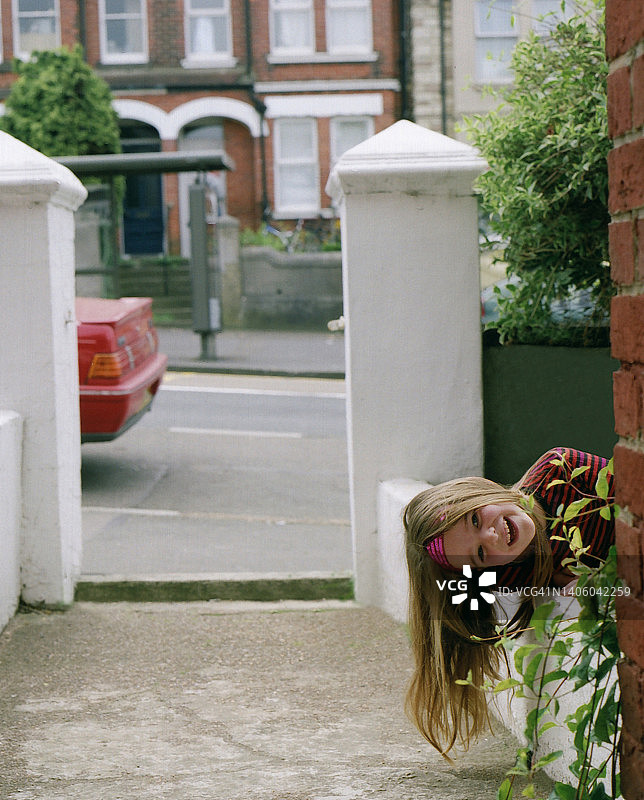 一个五岁女孩从墙后偷看图片素材