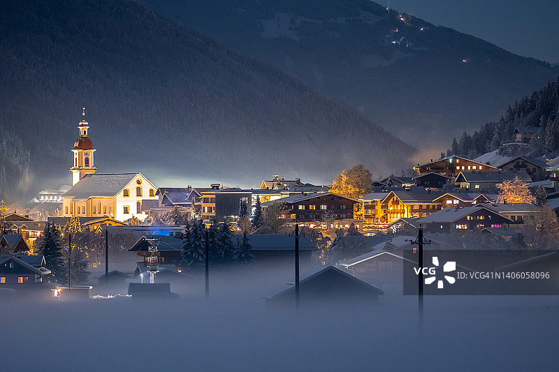 阿尔卑斯山的冬季景观：雾中的村庄图片素材