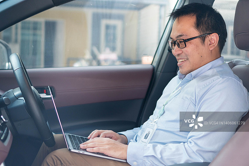 在车内使用笔记本电脑的亚洲成功商人图片素材
