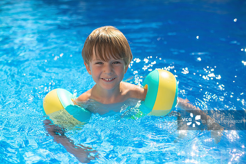可爱的男孩在游泳池里图片素材
