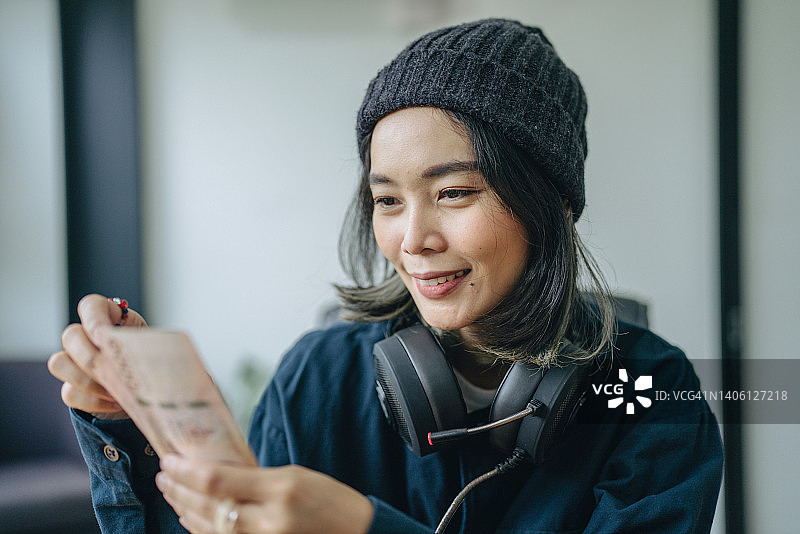 戴着游戏耳机在家玩电子游戏的年轻女人图片素材