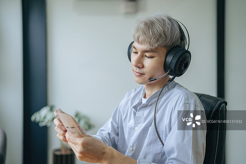 亚洲男子在笔记本电脑上玩电脑游戏并拿着钱图片素材