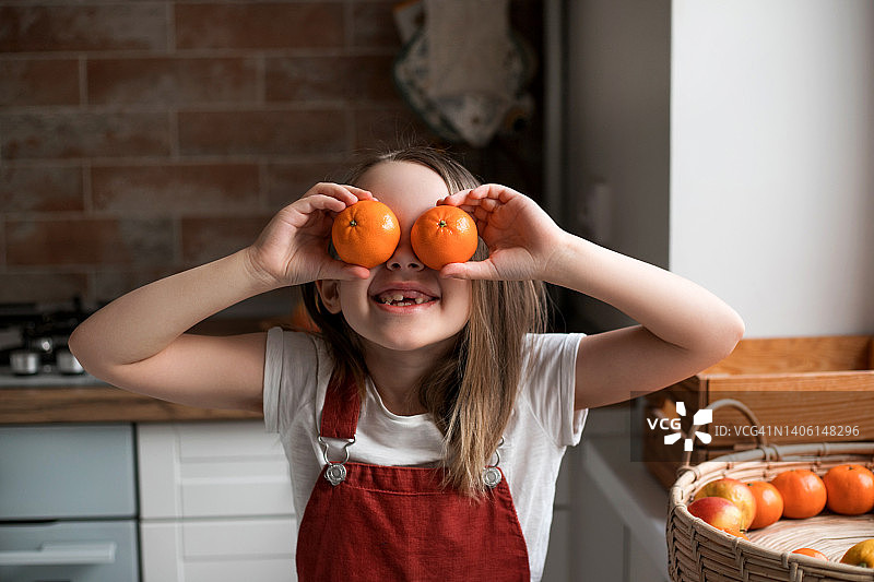 在家玩橘子的可爱小女孩图片素材