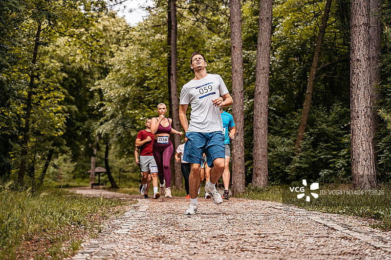 马拉松比赛中腿部受伤的年轻男人图片素材