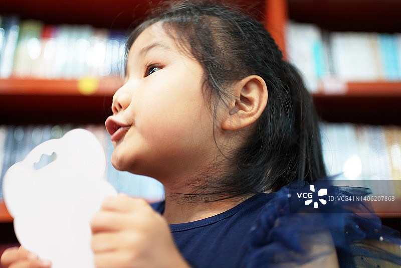 热爱学习的小女孩在图书馆里图片素材