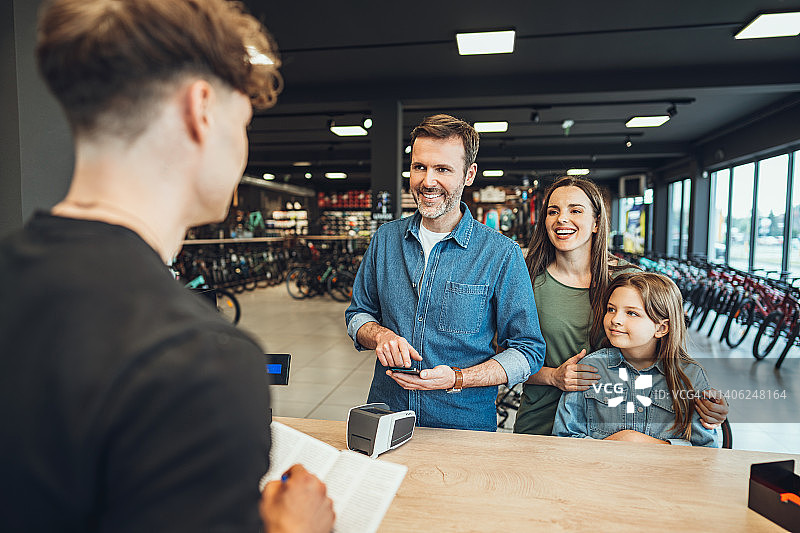 一家人在自行车店付款图片素材