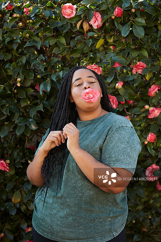 嘴里含着花的年轻黑人女性图片素材