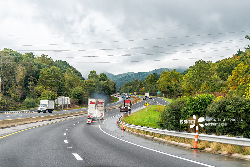 在北卡罗来纳州阿什维尔附近的i40州际公路上，卡车喷出的烟雾污染了公路上的Ridgecrest标志图片素材