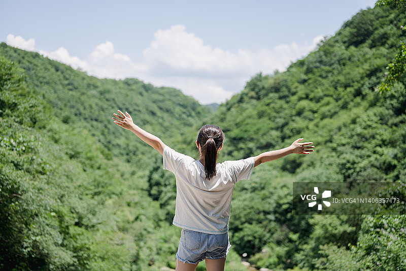 张开双臂的年轻女子背影图片素材