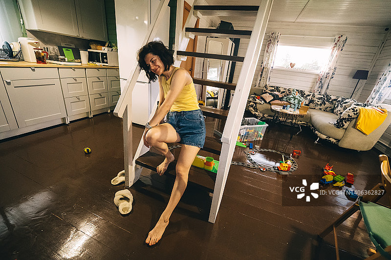 疲惫的妈妈坐在小屋房间的楼梯上图片素材