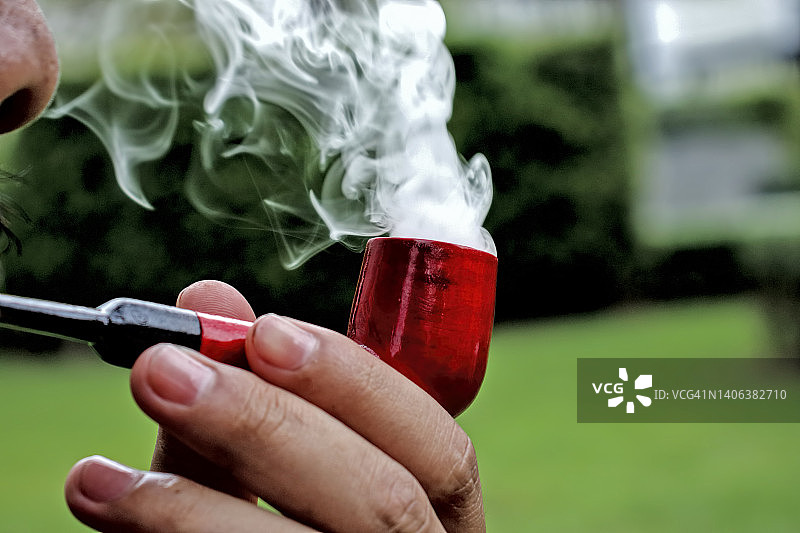 男人抽红色木制烟斗图片素材